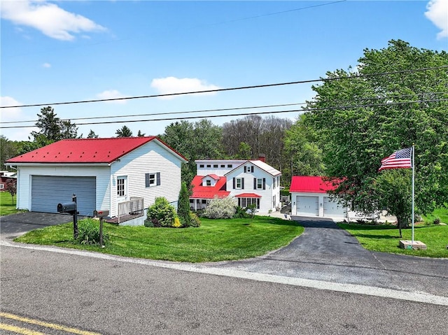 260 Stouffer Hill Rd, Somerset Twp, PA 15541 - view of front facade featuring a garage, a front lawn, a metal roof, and an outbuilding