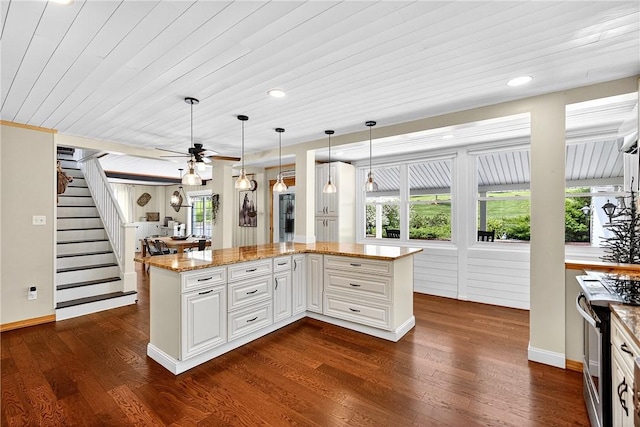 260 Stouffer Hill Rd, Somerset Twp, PA 15541 - kitchen with stainless steel range oven, dark wood-style floors, light stone counters, ceiling fan, and white cabinetry