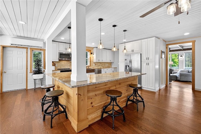 260 Stouffer Hill Rd, Somerset Twp, PA 15541 - kitchen with stainless steel appliances, wooden ceiling, dark wood finished floors, ceiling fan, and a kitchen breakfast bar
