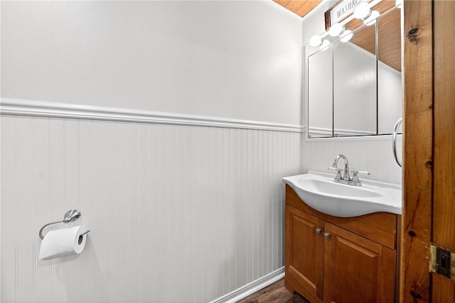 260 Stouffer Hill Rd, Somerset Twp, PA 15541 - half bathroom with vanity, a wainscoted wall, and wood finished floors
