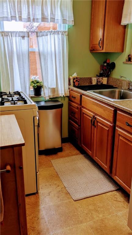 218 Bascom, Observatory Hill, PA 15214 - kitchen with white range with gas stovetop and brown cabinetry