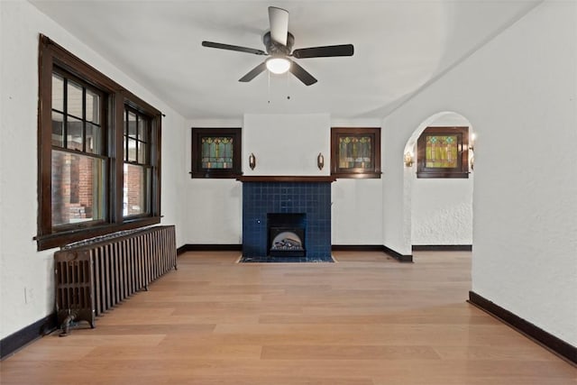 22 Beltzhoover Ave, Allentown, PA 15210 - unfurnished living room featuring radiator heating unit, a ceiling fan, light wood-style floors, and a tile fireplace