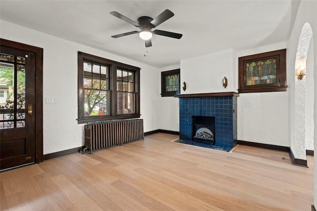 22 Beltzhoover Ave, Allentown, PA 15210 - unfurnished living room with radiator heating unit, light wood finished floors, ceiling fan, and a tiled fireplace