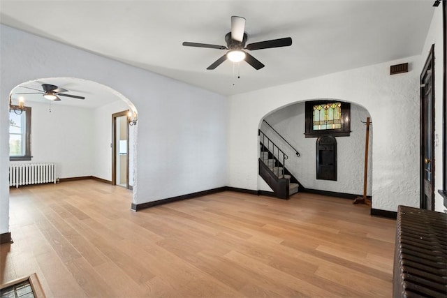 22 Beltzhoover Ave, Allentown, PA 15210 - unfurnished room with radiator, arched walkways, ceiling fan, and light wood finished floors