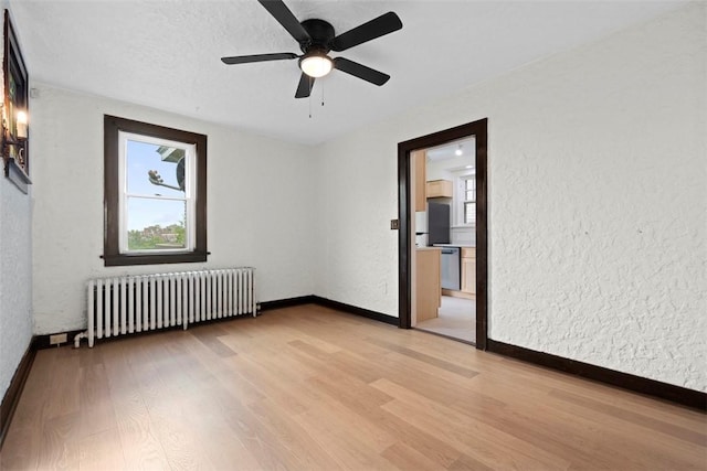 22 Beltzhoover Ave, Allentown, PA 15210 - spare room with radiator heating unit, light wood finished floors, a ceiling fan, and a textured wall
