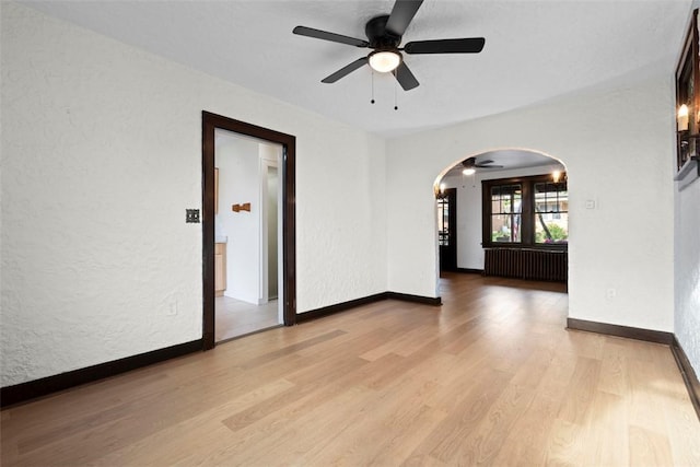 22 Beltzhoover Ave, Allentown, PA 15210 - unfurnished room with arched walkways, ceiling fan, light wood-style flooring, and a textured wall