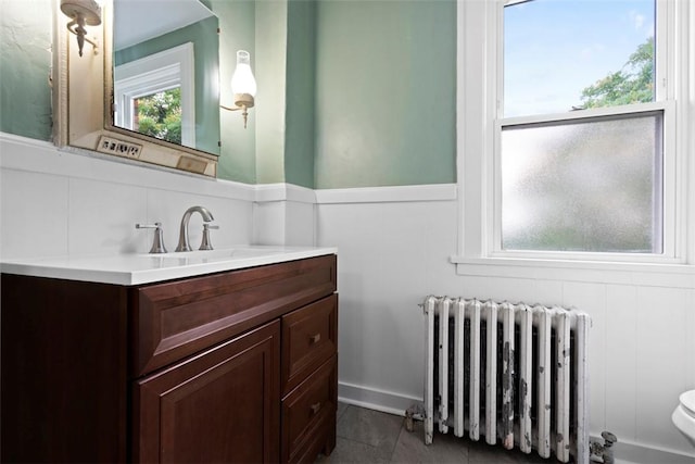 22 Beltzhoover Ave, Allentown, PA 15210 - bathroom with radiator heating unit, vanity, tile patterned flooring, and a decorative wall