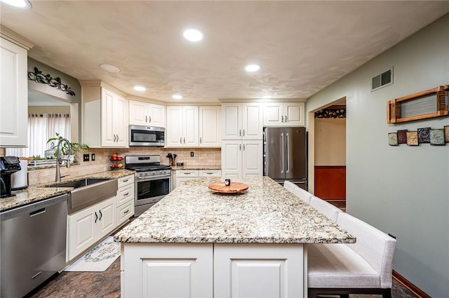 4025 Holiday Park Dr, Murrysville, PA 15668 - kitchen featuring stainless steel appliances, a kitchen island, backsplash, light stone countertops, and a breakfast bar
