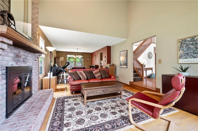 2507 Sarah Ct, Murrysville, PA 15668 - living area featuring light wood-style floors, stairway, a high ceiling, a brick fireplace, and a chandelier