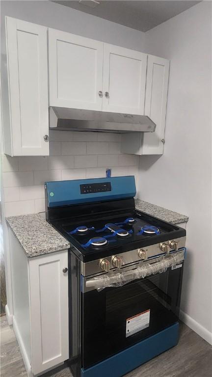 118 Brady Ave, City Of Washington, PA 15301 - kitchen featuring stainless steel gas stove, ventilation hood, white cabinetry, tasteful backsplash, and light wood-style flooring