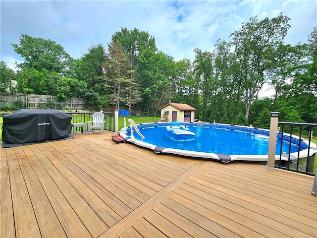 15 Pineview Ests, Sewickley Twp, PA 15089 - swimming pool with a fenced backyard, a deck, area for grilling, view of wooded area, and a storage shed