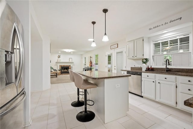 54 Colony Oaks Dr, Shaler, PA 15209 - kitchen featuring stainless steel appliances, a kitchen island, a breakfast bar, a brick fireplace, and hanging light fixtures