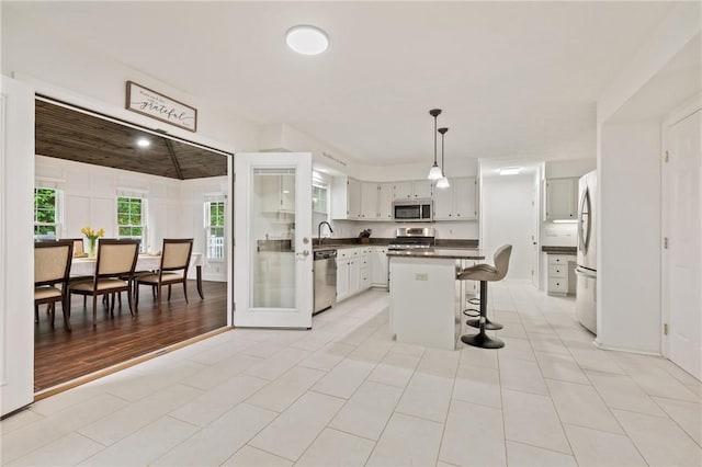 54 Colony Oaks Dr, Shaler, PA 15209 - kitchen featuring stainless steel appliances, dark countertops, a breakfast bar area, hanging light fixtures, and a center island