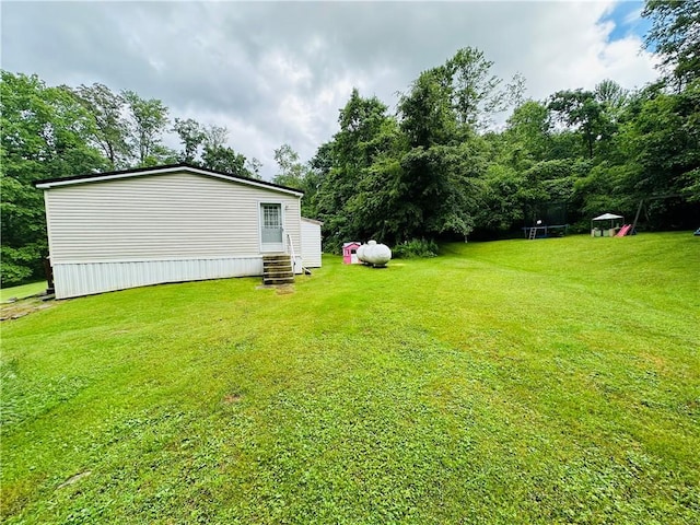 170 Hungarian Rd, Cherry Twp, PA 16057 - view of green lawn with entry steps, a trampoline, and view of scattered trees
