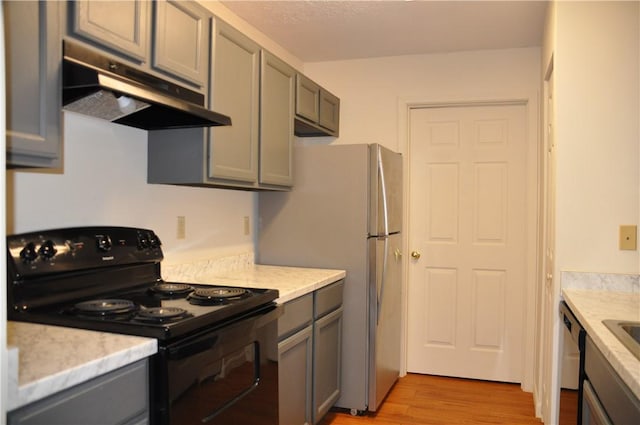 1101 Lenox Dr, Bethel Park, PA 15102 - kitchen with black range with electric cooktop, under cabinet range hood, gray cabinets, light wood-type flooring, and freestanding refrigerator