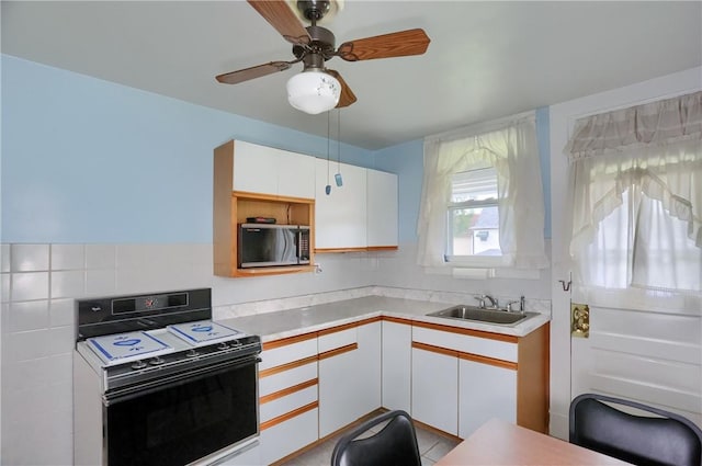 83 Evans Ave, Ingram, PA 15205 - kitchen with black range with electric cooktop, light countertops, white cabinetry, and a ceiling fan