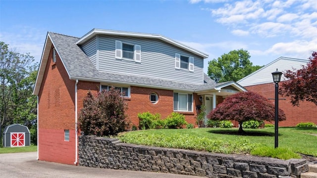 6623 Saltsburg Rd, Penn Hills, PA 15235 - traditional home featuring brick siding, a storage unit, a front lawn, and roof with shingles