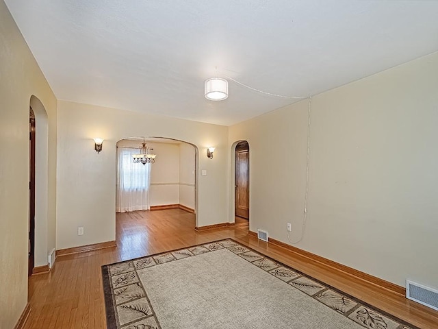 449 Woodland Rd, Canonsburg, PA 15317 - empty room with arched walkways, wood finished floors, and a chandelier