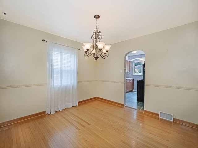 449 Woodland Rd, Canonsburg, PA 15317 - spare room featuring arched walkways, light wood-type flooring, and a chandelier