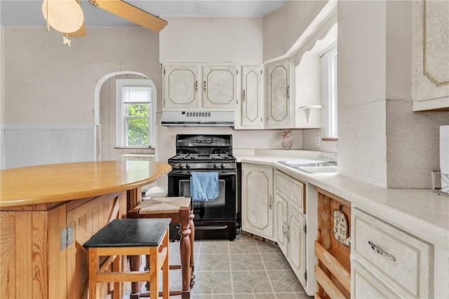 104 Highland Ave, Avella, PA 15312 - kitchen with black range with gas cooktop, range hood, light countertops, a kitchen bar, and light tile patterned flooring