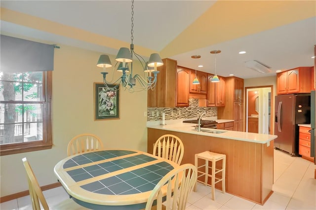 143 Hampshire Dr, Cranberry Twp, PA 16066 - kitchen with stainless steel fridge, decorative backsplash, a chandelier, a peninsula, and pendant lighting