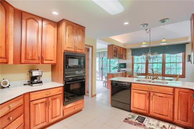 143 Hampshire Dr, Cranberry Twp, PA 16066 - kitchen featuring black appliances, hanging light fixtures, light tile patterned flooring, light countertops, and brown cabinets