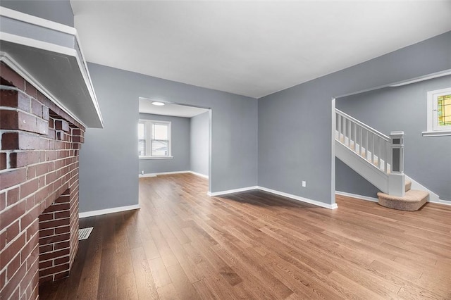 1014 Fordham Ave, Brookline, PA 15226 - unfurnished living room with stairs, wood finished floors, and plenty of natural light