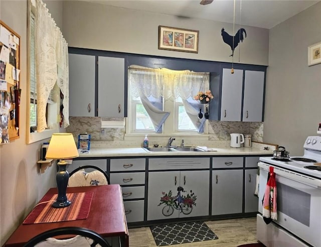 12311/2 Otter St, City Of Franklin, PA 16323 - kitchen with white range with electric cooktop, decorative backsplash, light countertops, gray cabinets, and light wood-type flooring