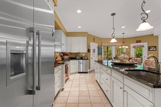 912 Field Club Rd, Ohara, PA 15238 - kitchen featuring appliances with stainless steel finishes, white cabinetry, light tile patterned floors, dark stone counters, and pendant lighting