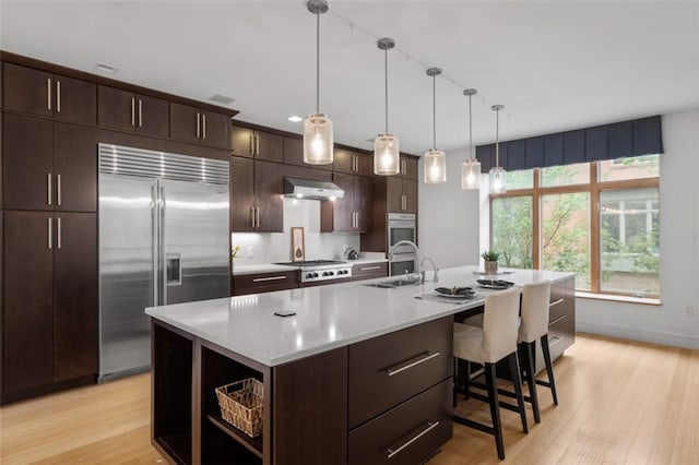 1821 Merriman, South Side, PA 15203 - kitchen with stainless steel appliances, light wood-type flooring, light countertops, and an island with sink