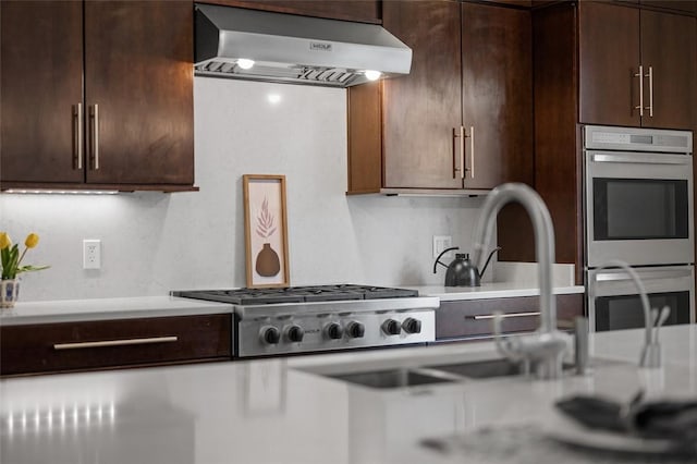 1821 Merriman, South Side, PA 15203 - kitchen featuring wall chimney range hood, appliances with stainless steel finishes, light countertops, and dark brown cabinets