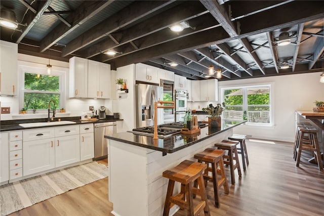 812 Franklin Rd, Pine Twp Nal, PA 16046 - kitchen with stainless steel appliances, light wood finished floors, dark countertops, a kitchen bar, and white cabinets