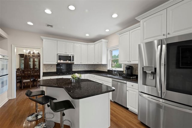 7052 Bennington Woods Dr, Mccandless, PA 15237 - kitchen with appliances with stainless steel finishes, wood finished floors, white cabinets, and recessed lighting
