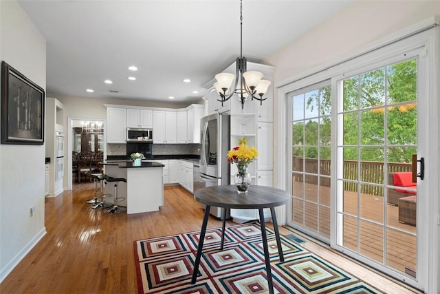 7052 Bennington Woods Dr, Mccandless, PA 15237 - kitchen with a chandelier, appliances with stainless steel finishes, tasteful backsplash, dark countertops, and a center island