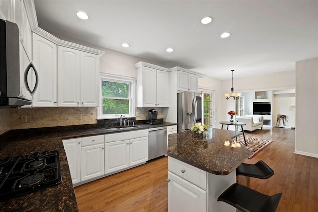 7052 Bennington Woods Dr, Mccandless, PA 15237 - kitchen featuring stainless steel appliances, a breakfast bar area, light wood-style floors, white cabinetry, and recessed lighting