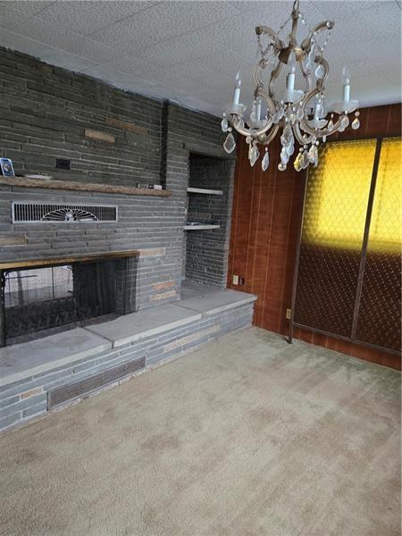 192 Crowe Ave, Mars Boro, PA 16046 - unfurnished living room with carpet, a chandelier, and a brick fireplace
