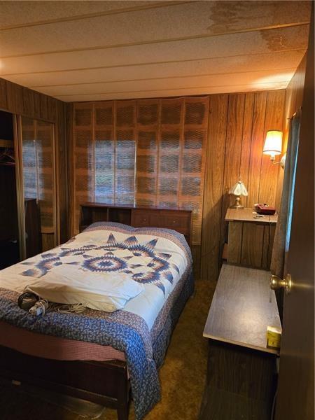 192 Crowe Ave, Mars Boro, PA 16046 - bedroom with wood walls and carpet floors