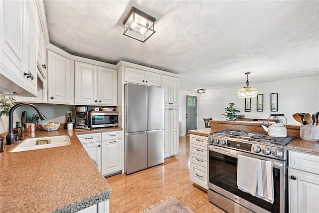 4047 Crestwood Dr, West Deer, PA 15044 - kitchen featuring stainless steel appliances, white cabinetry, light countertops, decorative light fixtures, and light wood finished floors
