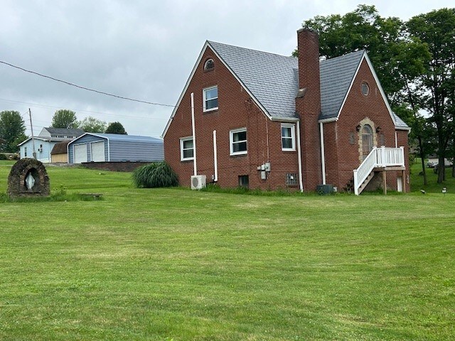 300 6th Ave, New Eagle, PA 15067 - view of property exterior with brick siding, a yard, a chimney, and a detached garage