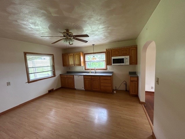 300 6th Ave, New Eagle, PA 15067 - kitchen with white appliances, arched walkways, light wood-style flooring, ceiling fan, and brown cabinets