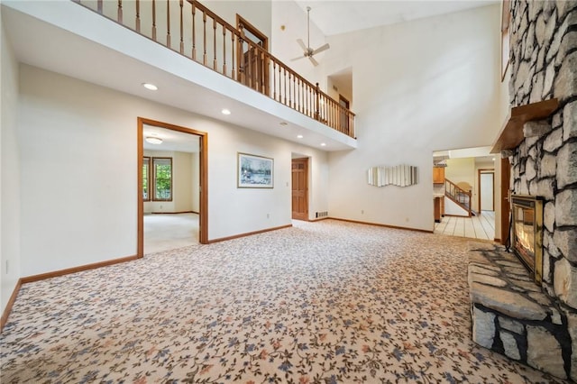4751 Millstream Ct, Murrysville, PA 15668 - unfurnished living room with carpet, a ceiling fan, a fireplace, stairs, and a towering ceiling