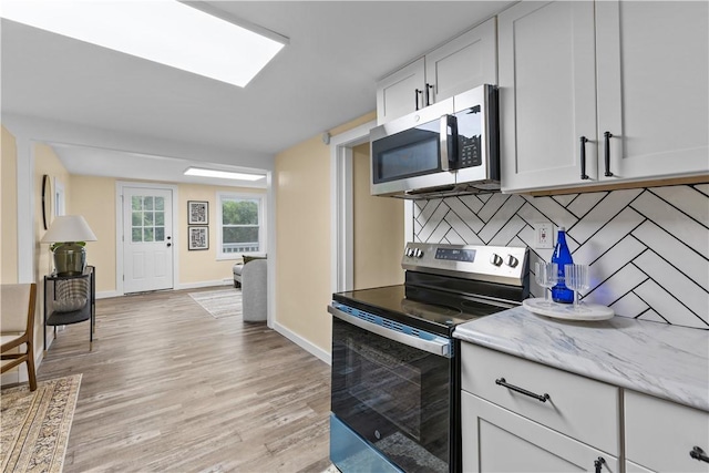 466 Braden School Rd, Chippewa Twp, PA 15010 - kitchen featuring appliances with stainless steel finishes, light wood-type flooring, white cabinets, and light stone counters