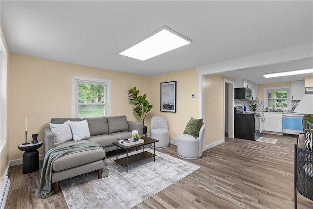466 Braden School Rd, Chippewa Twp, PA 15010 - living area with plenty of natural light, wood finished floors, and a baseboard radiator