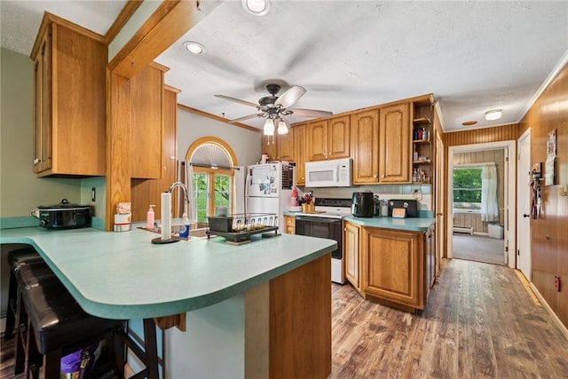 119 Taylor Rd, Quemahoning Twp, PA 15541 - kitchen with white appliances, a peninsula, wood finished floors, brown cabinetry, and a textured ceiling
