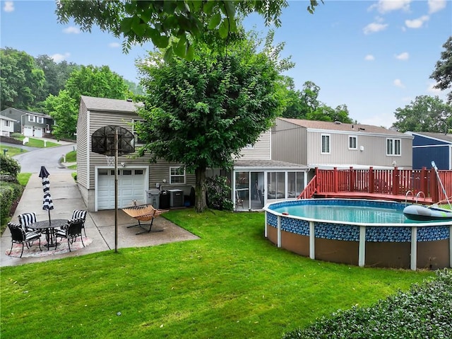 1304 Greenhill Road Ext, Shaler, PA 15209 - rear view of house featuring a sunroom, an attached garage, a yard, an outdoor pool, and a patio area