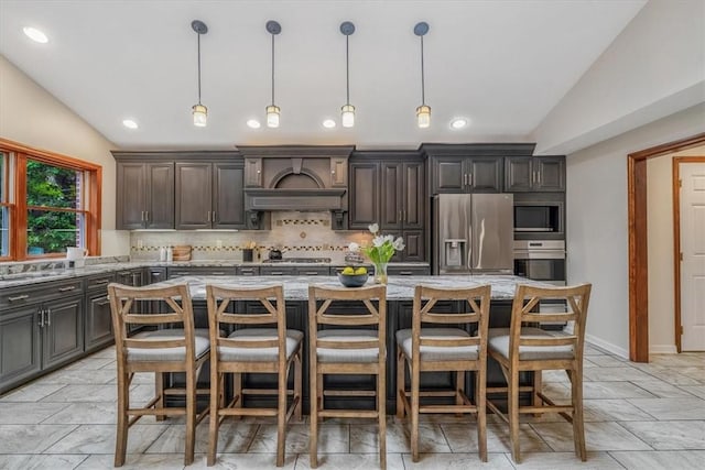 38 Easton Rd, Fox Chapel, PA 15238 - kitchen with appliances with stainless steel finishes, vaulted ceiling, decorative backsplash, light stone counters, and a center island