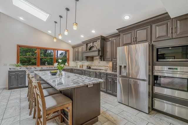 38 Easton Rd, Fox Chapel, PA 15238 - kitchen with appliances with stainless steel finishes, a skylight, light stone countertops, a warming drawer, and recessed lighting