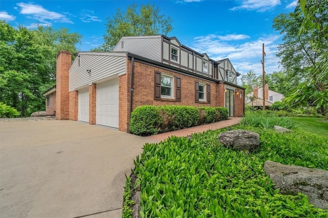 38 Easton Rd, Fox Chapel, PA 15238 - view of side of home with brick siding, an attached garage, and concrete driveway