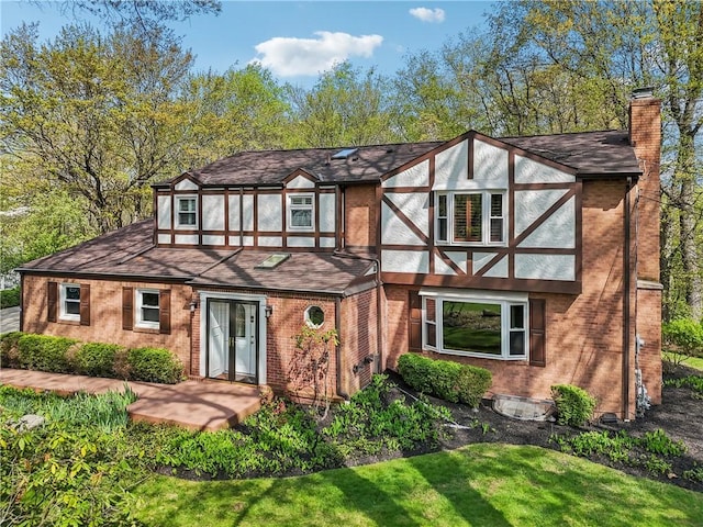 38 Easton Rd, Fox Chapel, PA 15238 - tudor house with a chimney, a shingled roof, brick siding, and a front yard