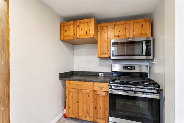 1027 Goldenrod St, Homestead, PA 15120 - kitchen with stainless steel appliances, dark countertops, and brown cabinetry